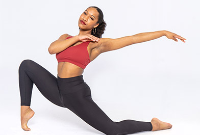A girl in a red top doing a dance pose for a picture