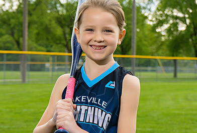 Young Girls from the Lakeville Lightning Softball Team Holding a bat Photo