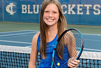 A Girl From Cambridge-Isanti Tennis Holding a Tennis Racket on a Tennis Court.