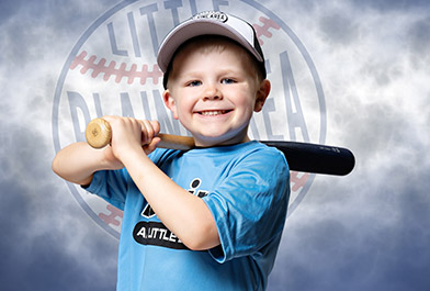 A young boy holding a baseball bat posing for a picture.